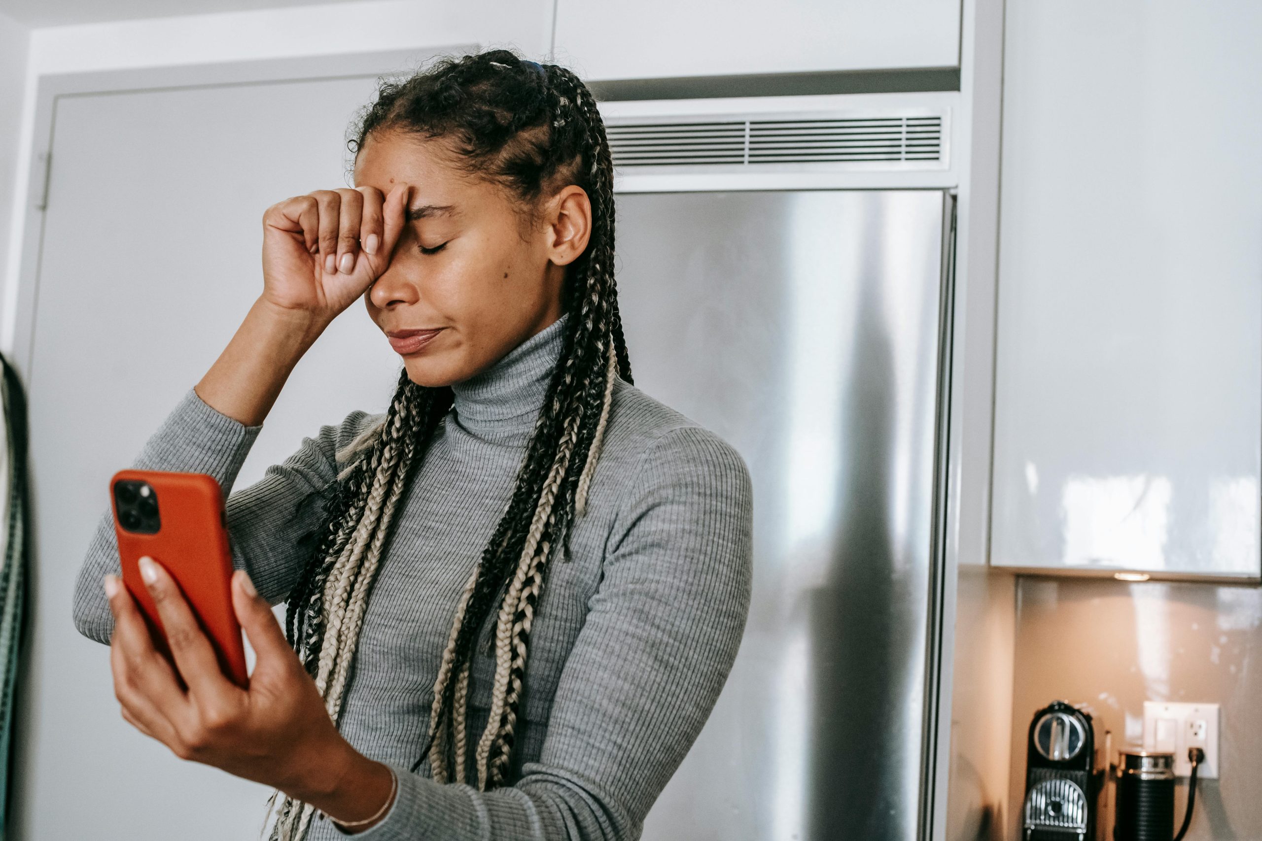 A parent looking anxious while tracking their child remotely. Electronic trackers on school trips can cause worry for parents!